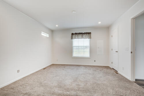 Empty room with carpet and white walls.