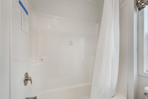 A bathroom with a white shower curtain and toilet.