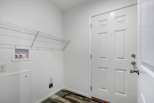 A hallway with a door and a rack.